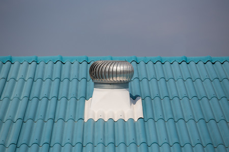 aluminum ventilator on blue roofの写真素材