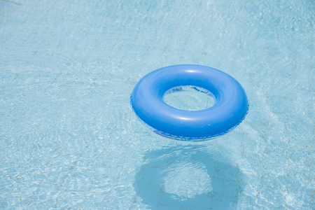 blue swim ring for children float on swimming pool isolatedの写真素材