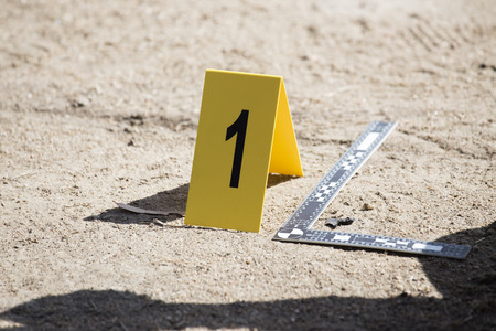 evidence marker and ruler scale of evidence  with law enforcement hand backgroundの写真素材