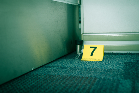 evidence marker number 7 on carpet floor with suspect object in crime scene investigation with copy space and cinematic toneの写真素材