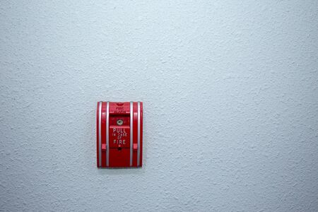 red fire alarm switch on blue wall background with copy spaceの写真素材