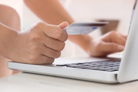 Woman hold Credit Card on laptop waiting for online shoppingの写真素材