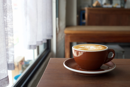 Coffee morning on wood table near window with morning light.の写真素材