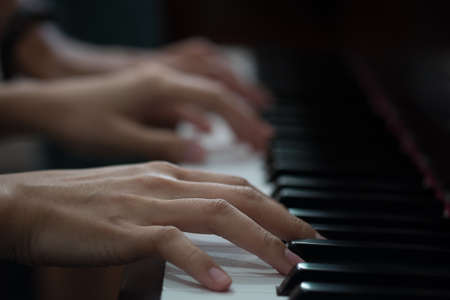 Piano with players hands,vintage and dark tone photo.の写真素材