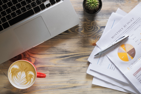 Office wood table with notepad, computer and coffee cup. View from above with copy spaceの写真素材