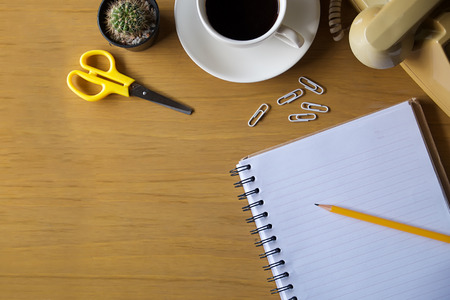 Office table with notepad, card , wallet , scissor and coffee cup. View from above with copy space,vintage effect.の写真素材