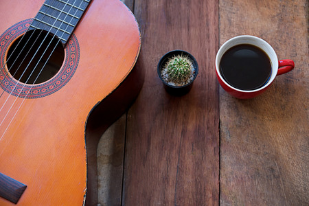 coffee cup and guitar on wooden tableの写真素材