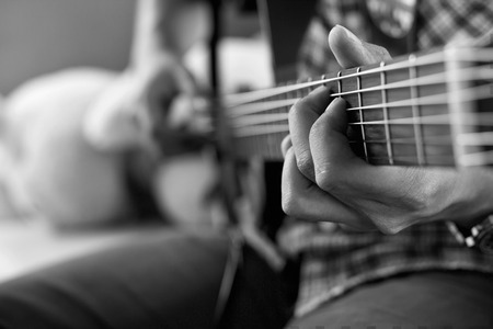 playing acoustic guitar, barre chord,selective focus,black and white tone.の写真素材