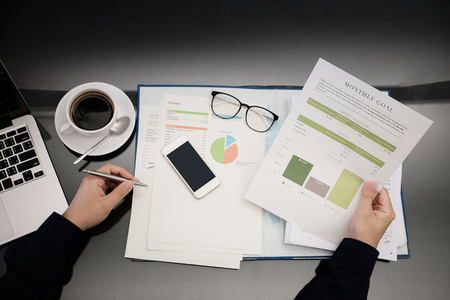 Businessman working at office desk with paperwork and other objects around, top viewの写真素材
