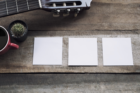 Empty three paper on wood desk and guitar,cup of coffee with copy space.の写真素材