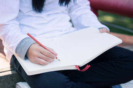 Kid writing on note paper.の写真素材