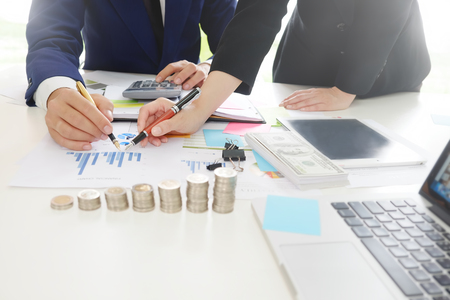 Business adviser analyzing financial,Financial planning Business man and Business woman talking to planner financial business, report finance in paper on office accounting.の写真素材