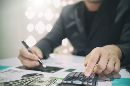 Business man doing finances on calculate analysis working with financial results Financial...