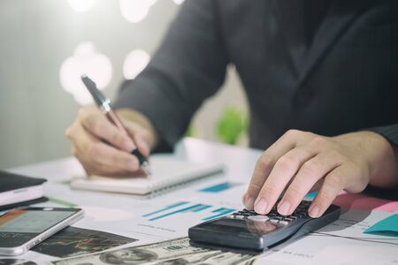Business man doing finances on calculate analysis working with financial results Financial...