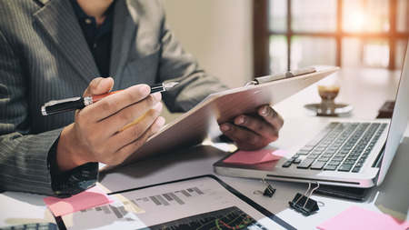 Audit concept,Bookkeeper or financial inspector and secretary making report Financial Planning Report in Spreadsheet .Internal revenue Service inspector checking financial document vintage tone.の写真素材