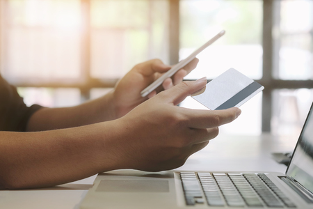 Hands holding credit card and entering security code using smart phone online shopping concept.の写真素材