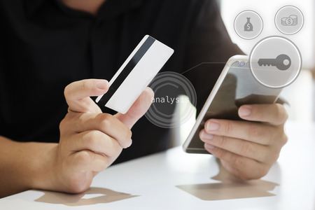 Man paying with credit card on smart phone at home office buy online e-commerce concept.の写真素材
