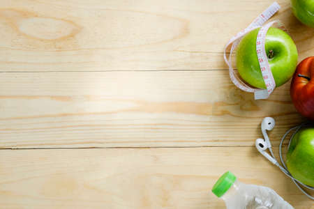 Healthy lifestyle concept. Green and Red Apples,water bottles and stop watch on wooden table copy space for add your text or product.の写真素材