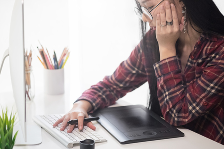 Creative woman working in creative office with computer and gadget or device on artist desk, graphic design concept.の写真素材