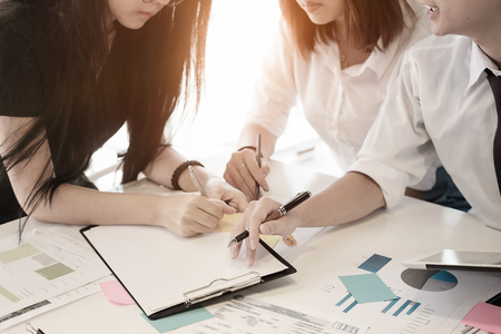 Three business partners discussing documents and ideas at meeting,business consulting concept.の写真素材