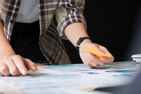Woman holding a paper note in office with selective focus in right hand.の写真素材