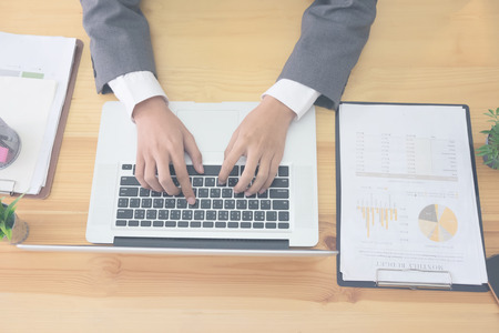 Business using laptop computer hand typing keyboard on business office.