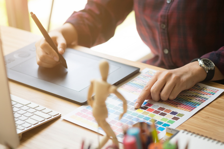 Young woman Graphic designer using interactive pen display, digital Drawing tablet and Pen on a computer.の写真素材
