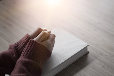 Woman pray on holy bible in the morning.Closeup hand with Bible praying,spirituality and religion with vintage tone.の写真素材