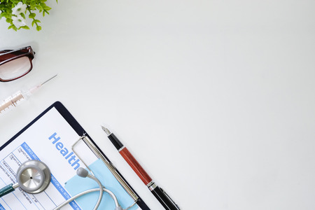 Medical equipment,White background with stethoscope, clipboard, pen, medical syringe and glasses in a physician's office, Mock up.の写真素材