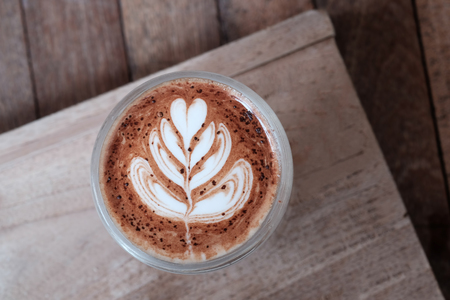Closeup latte art in coffee cup on wooden.の写真素材