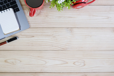 Office wooden desk table with other supplies with laptop computer and cup of coffee.の写真素材