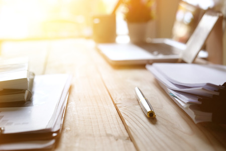 business equipment pen and paper document on wooden table in modern office with copy space and morning light.の写真素材