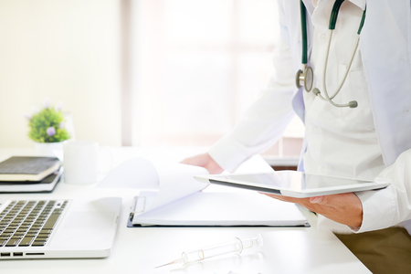 Medical Technology , Close up doctor reading a report in tablet computer on workplace.の写真素材