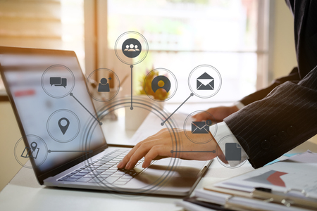 businessman hand working with laptop computer in modern office with virtual icon diagram at modern office in morning lightの写真素材