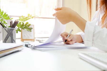 Close up audit woman calculate on paper document financial data.の写真素材