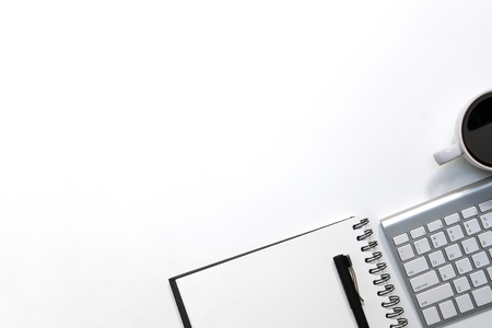 Modern white office desk table with keyboard computer, coffee, pen and notebook paper with workspace top view workspace.の写真素材