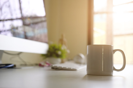 Mug of coffee on office workplace with morning coffee concept.の写真素材