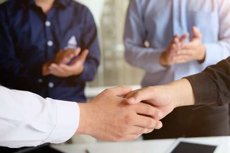 Acquisition concept Business Partnership shaking hands finishing up a meeting.の写真素材