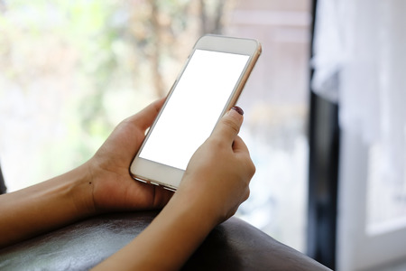 Side view woman hands using smartphone mock up.の写真素材