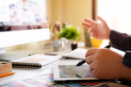 Graphic designer using digital tablet and computer in the office with morning light.の写真素材