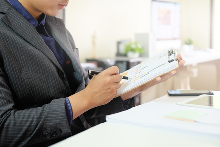 Businessman checklist on chart board paper working on table.の写真素材