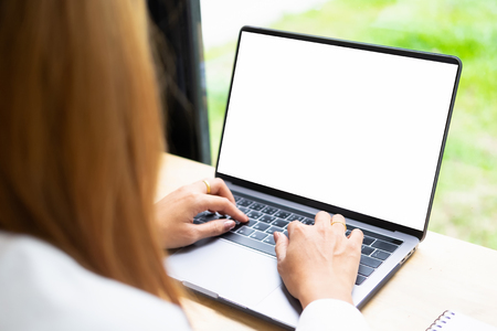 Woman using mockup laptop computer with white screen display.の写真素材