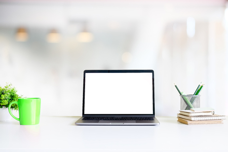 Office workspace mockup laptop computer, mug of coffee, jar of pencil and book on table.の写真素材