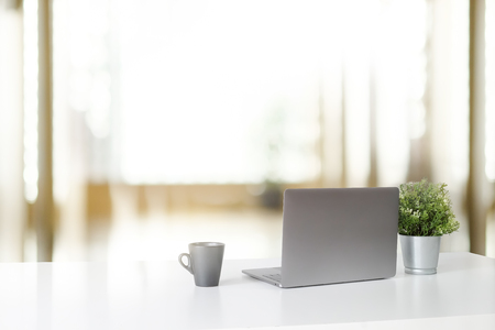 Workspace with laptop computer and coffee cup and plant, Stylish office desk work back view concept.の写真素材