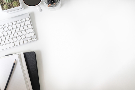 Flat lay, top view office table desk. Workspace with notebook, computer, office supplies, pencil and coffee cup on white desk.の写真素材