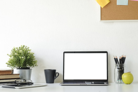 Mockup laptop computer,book and office supplies on white desk.の写真素材