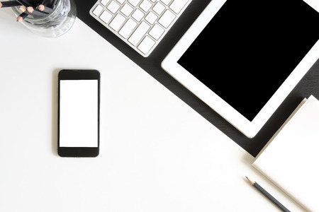 Mockup smartphone on table with tablet and notebook with pen A top view office desk, A monotone object concept.の写真素材