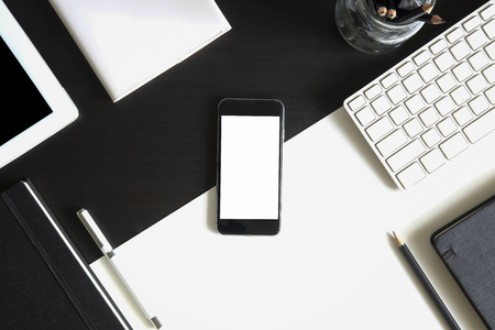 Mockup smartphone on table with tablet and notebook with pen A top view office desk, A monotone object concept.の写真素材