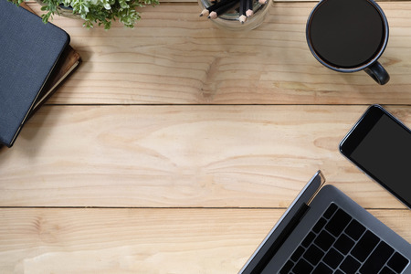 Office desk a laptop, coffee, book, pencil and smartphone on copy space workspace table top view with wood texture.の写真素材
