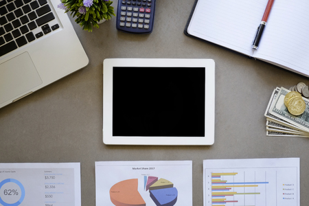 Workspace of data analysis concept, empty tablet on desk and data business in paper with finance...